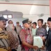 Penjabat (Pj.) Bupati Aceh Jaya, Dr. A. Murtala, M.Si, menyerahkan sertifikat hak atas tanah Pendaftaran Tanah Sistematis Lengkap (PTSL) secara simbolis kepada masyarakat Desa Alue Pande, Kecamatan Panga, Kamis (11/01/2024) (Foto untuk AJP)