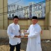 Calon Wakil Gubernur Aceh Fadlullah menerima hadiah buku dari anak keuchik Leumiek, di halaman Mesjid Keuchik Leumiek, Banda Aceh, Jumat (11/10/2024).
