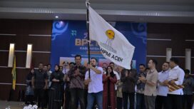 Fitra Akhyar mengibarkan petaka saat pelantikan HIPMI Aceh Jaya periode 2025 - 2028 di Aula DPMPKB Aceh Jaya, Kamis (9/1/2025) (Foto/Ist)