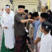 Bupati Aceh Jaya, Safwandi, menyerahkan santunan kepada puluhan anak yatim di Masjid Agung Baitul Izzah, Minggu (16/3/2025) (Foto/Ist)