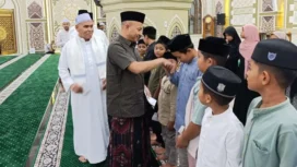 Bupati Aceh Jaya, Safwandi, menyerahkan santunan kepada puluhan anak yatim di Masjid Agung Baitul Izzah, Minggu (16/3/2025) (Foto/Ist)