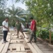Anggota Dewan Perwakilan Rakyat Kabupaten (DPRK) Aceh Jaya, Usman ID meninjau jembatan penyeberangan dari Desa Lamteungoh menuju Desa Panton Krueng, Kecamatan Darul Hikmah yang kini sedang rusak parah, Senin (4/8/2025) (Foto/AJP - Putri) 