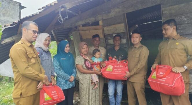 
 Bupati Safwandi beri bantuan masa panik kepada keluarga Zamzami yang rumahnya tertimpa pohon.