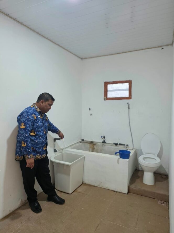 
 Kadisdikbud Aceh Jaya, Juanda saat mengecek kebersihan kamar mandi di sekolah.